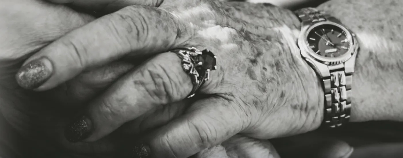 Close up of elderly people holding hands.