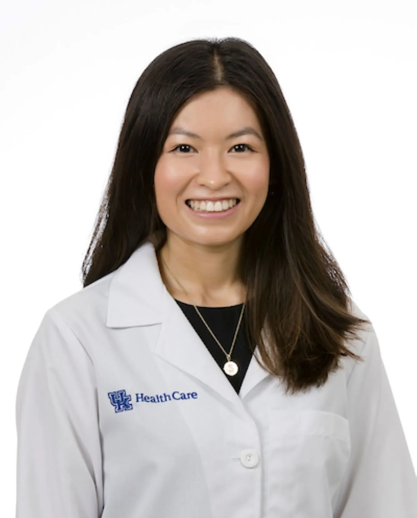 Sydney Masters smiling for her white coat headshot.