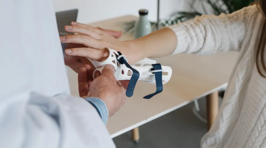 Doctor helping patient with a hand brace